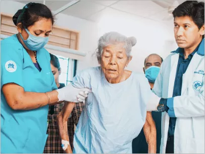 Nurses helping an elderly patient walk